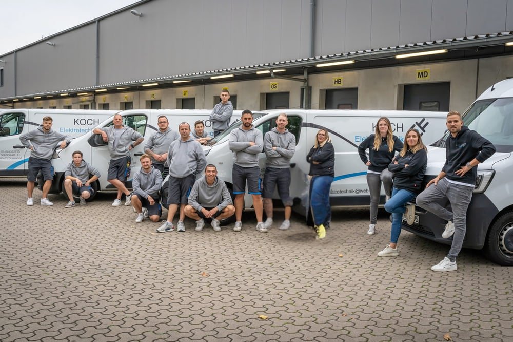 Das Team von Koch Elektrotechnik vor dem Fuhrpark